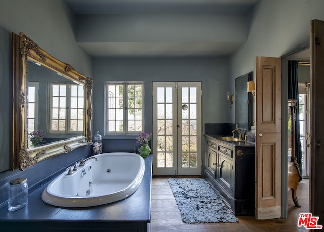 bathroom with a tub, wood-type flooring, vanity, and french doors