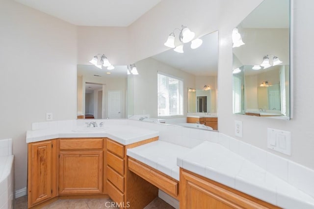 bathroom featuring tile patterned flooring, vanity, and a bath