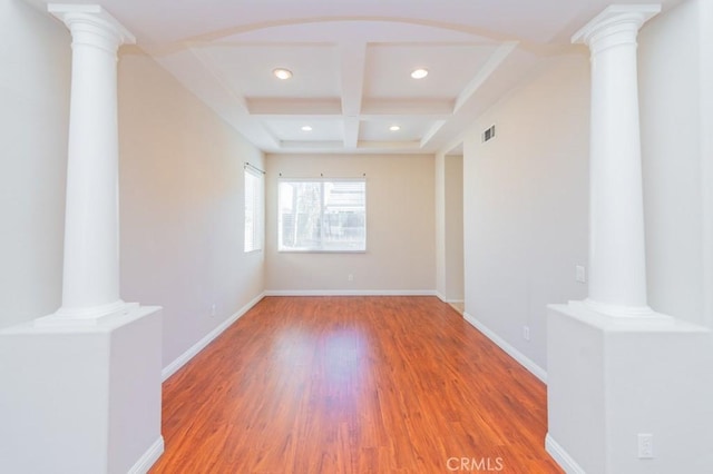 unfurnished room featuring ornate columns, wood-type flooring, coffered ceiling, and beamed ceiling