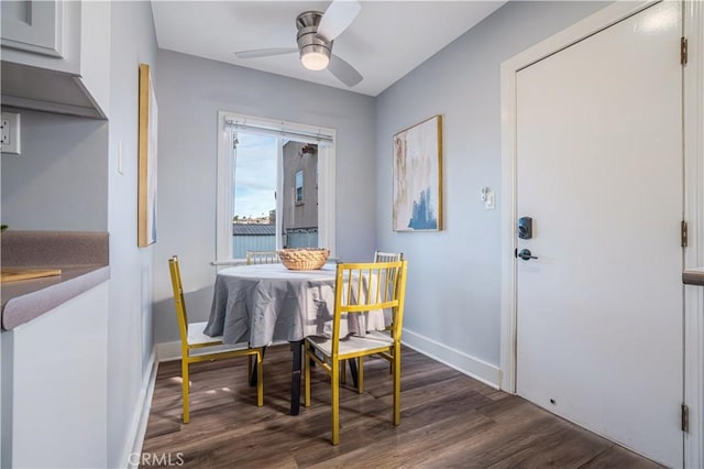 dining area with dark wood-type flooring and ceiling fan