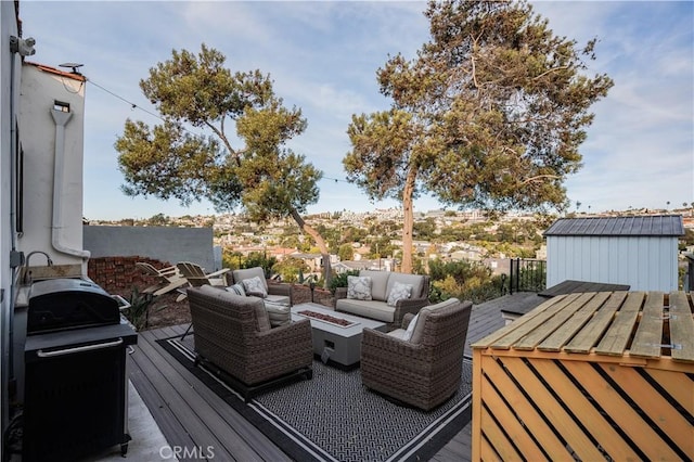 deck with area for grilling and an outdoor living space with a fire pit