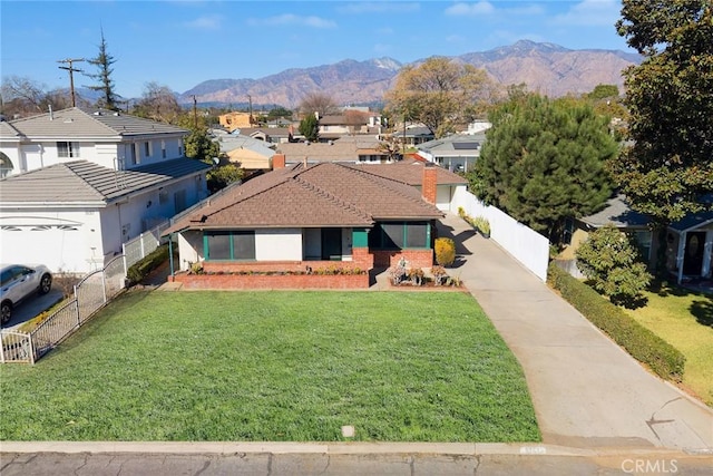 view of front of home featuring a mountain view and a front lawn