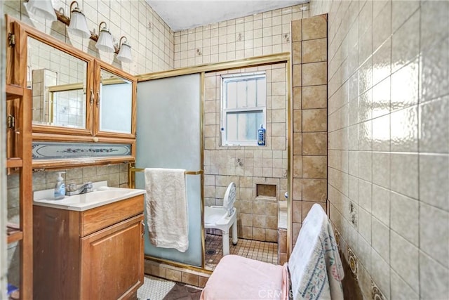 bathroom featuring tile patterned floors, vanity, backsplash, tile walls, and walk in shower