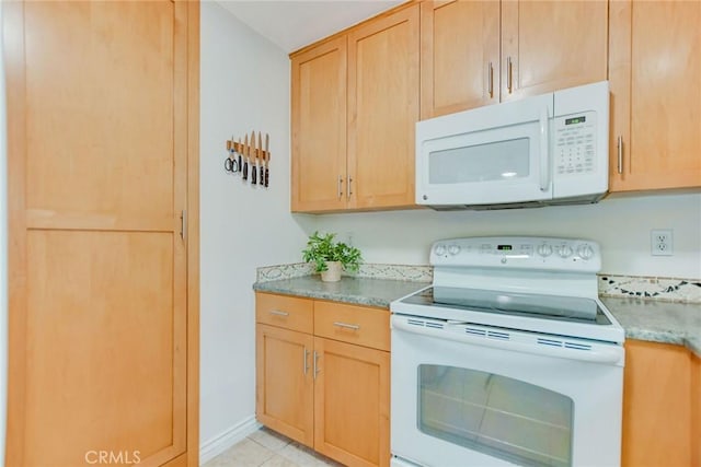 kitchen with light stone counters, white appliances, light brown cabinets, and light tile patterned flooring