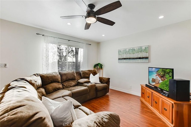 living room with ceiling fan and light hardwood / wood-style flooring