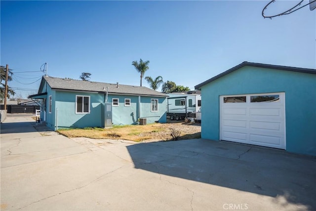 ranch-style home with a garage and central AC