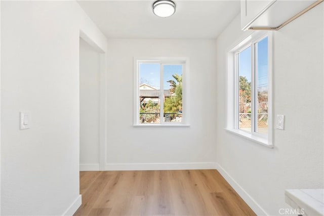 spare room with a healthy amount of sunlight and light hardwood / wood-style floors