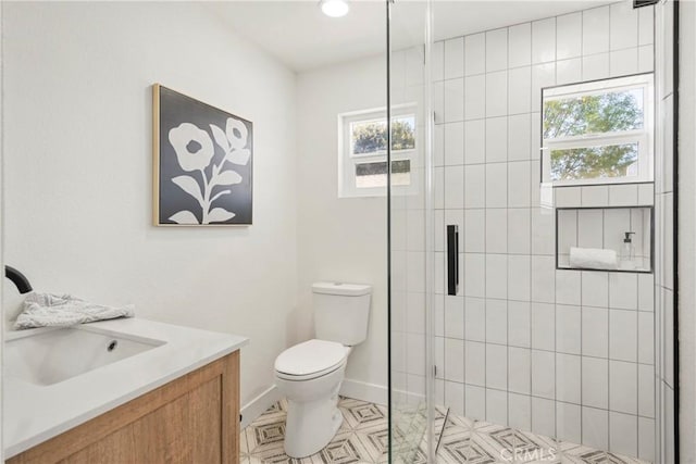 bathroom with walk in shower, a healthy amount of sunlight, vanity, and toilet