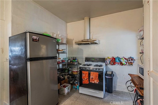 kitchen featuring white gas range oven, stainless steel refrigerator, and exhaust hood