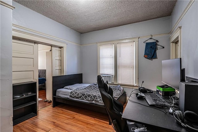 bedroom featuring a closet, a textured ceiling, and wood-type flooring