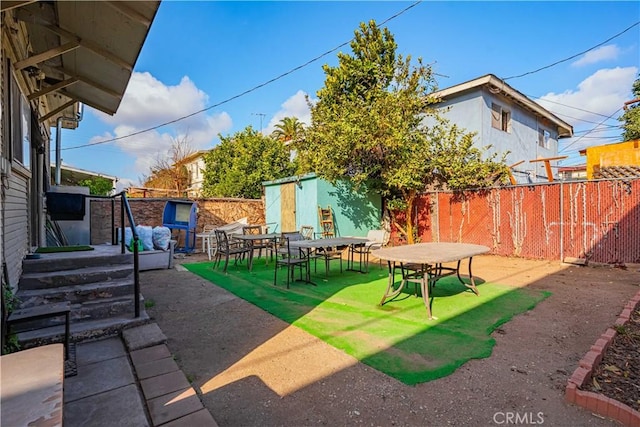 view of yard with a patio and a storage shed