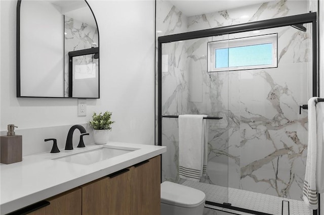 bathroom with vanity, a shower with shower door, and toilet