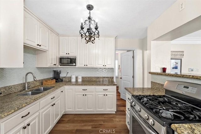 kitchen featuring sink, white cabinetry, decorative light fixtures, stainless steel appliances, and light stone countertops