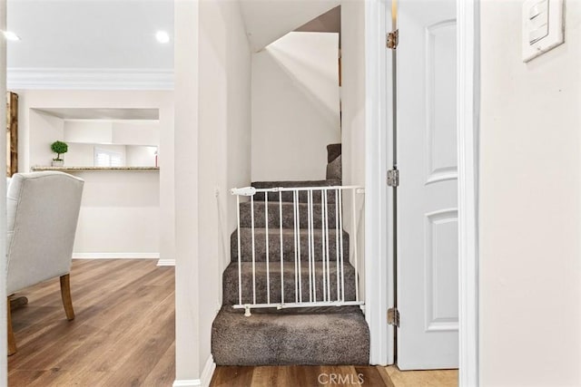 stairway featuring hardwood / wood-style flooring and ornamental molding