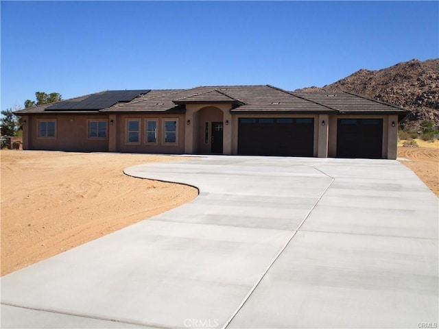 prairie-style home with a garage and solar panels