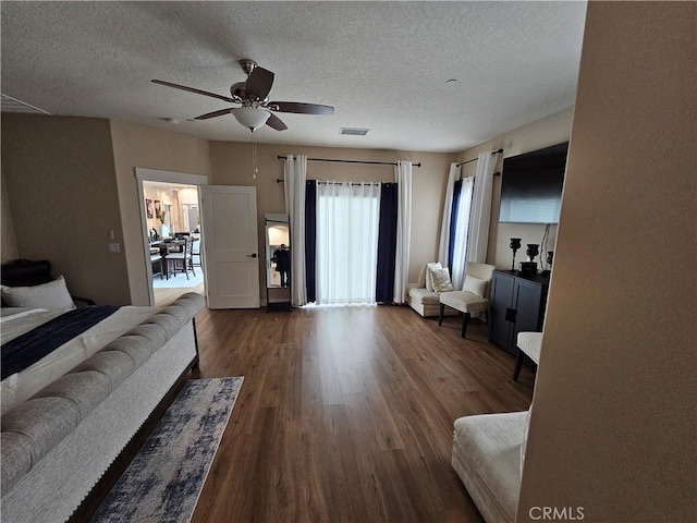 living room with hardwood / wood-style floors, a textured ceiling, and ceiling fan