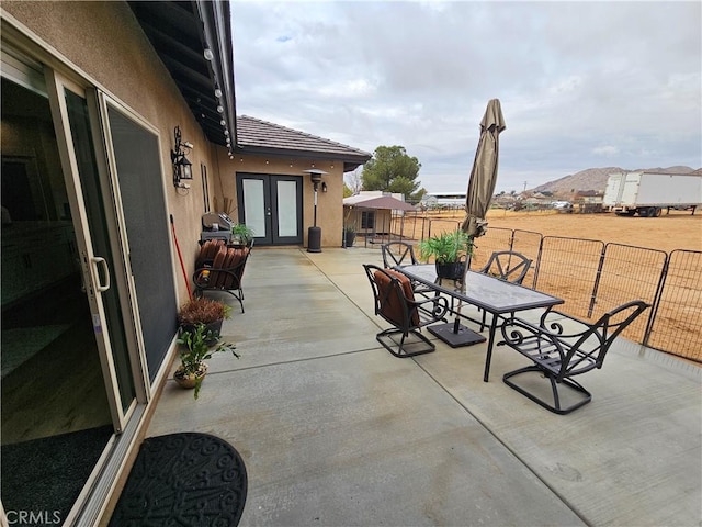 view of patio / terrace with a mountain view and french doors