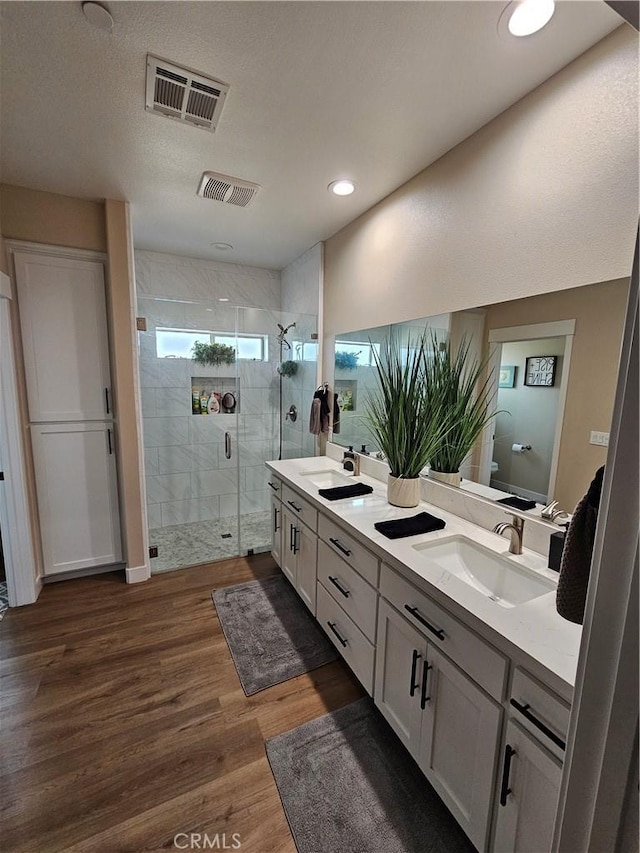 bathroom with walk in shower, wood-type flooring, toilet, and vanity