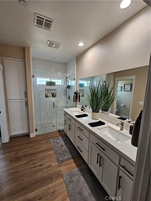 bathroom featuring hardwood / wood-style flooring, vanity, toilet, and a shower with door