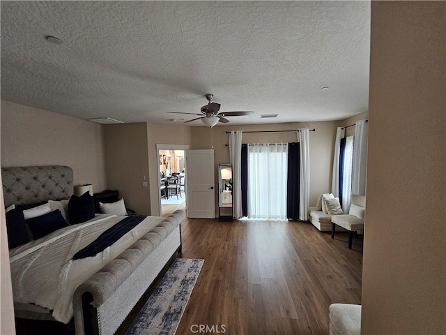 bedroom with hardwood / wood-style flooring, ceiling fan, access to exterior, and a textured ceiling