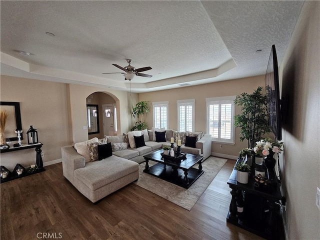 living room with hardwood / wood-style flooring, a raised ceiling, and a textured ceiling