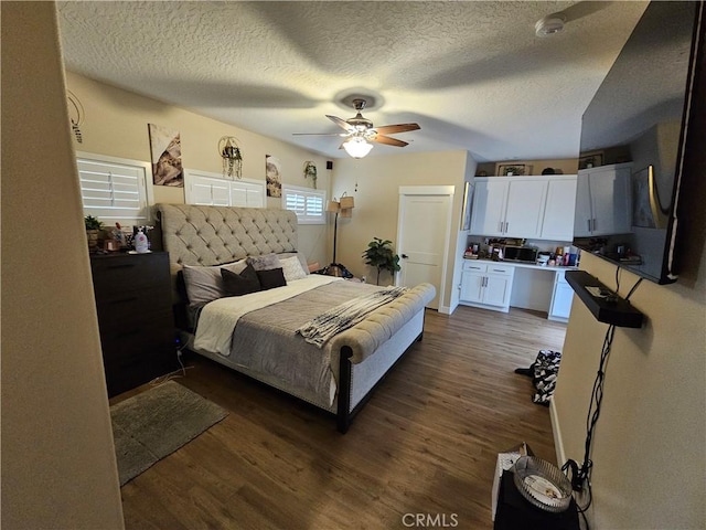 bedroom with a textured ceiling, dark hardwood / wood-style floors, and ceiling fan