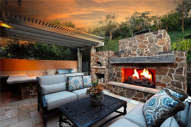 patio terrace at dusk featuring an outdoor living space with a fireplace