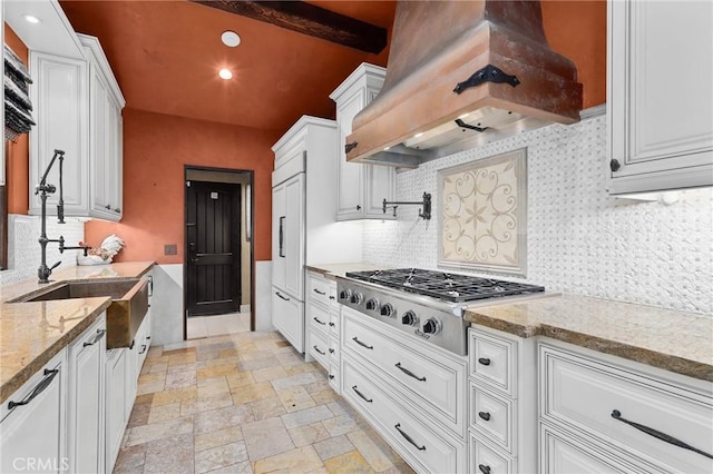 kitchen with stainless steel gas stovetop, white cabinetry, beamed ceiling, backsplash, and custom range hood