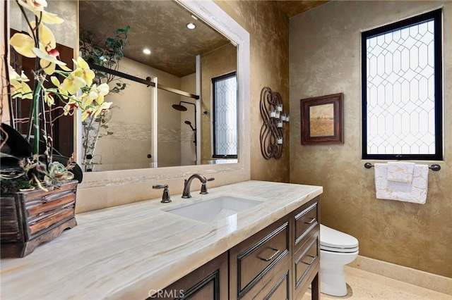 bathroom with walk in shower, vanity, and toilet