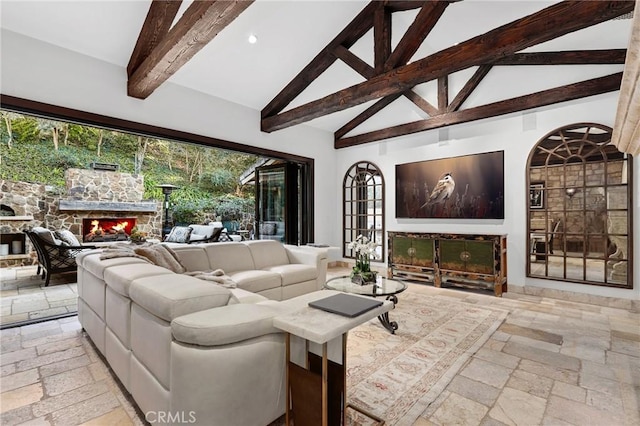 living room with a stone fireplace, high vaulted ceiling, and beam ceiling