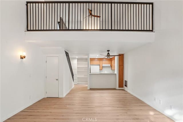 unfurnished living room featuring ceiling fan and light hardwood / wood-style floors