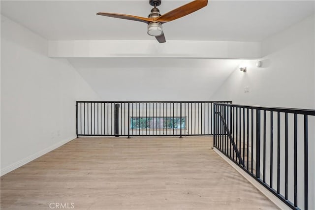 interior space with light hardwood / wood-style floors, ceiling fan, and vaulted ceiling with beams