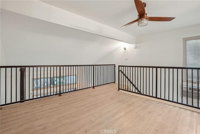 spare room featuring ceiling fan, light hardwood / wood-style flooring, and lofted ceiling with beams