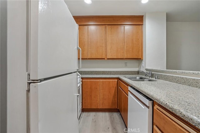 kitchen featuring sink, stainless steel dishwasher, white refrigerator, and light hardwood / wood-style flooring