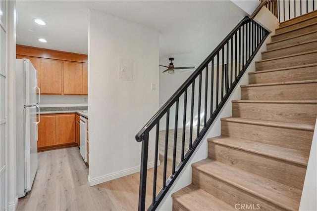 staircase featuring hardwood / wood-style flooring and ceiling fan