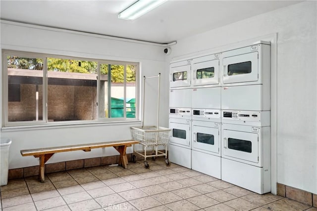 laundry room featuring stacked washer / dryer and light tile patterned floors