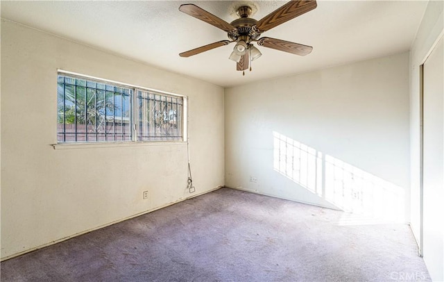 empty room with ceiling fan and carpet flooring