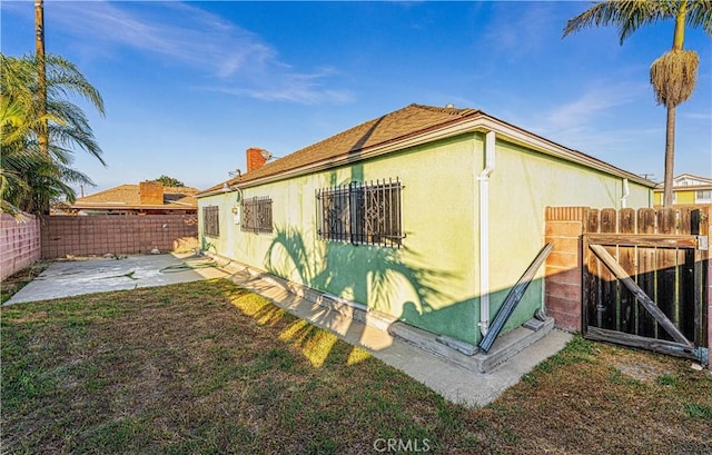 view of property exterior featuring a patio area and a lawn