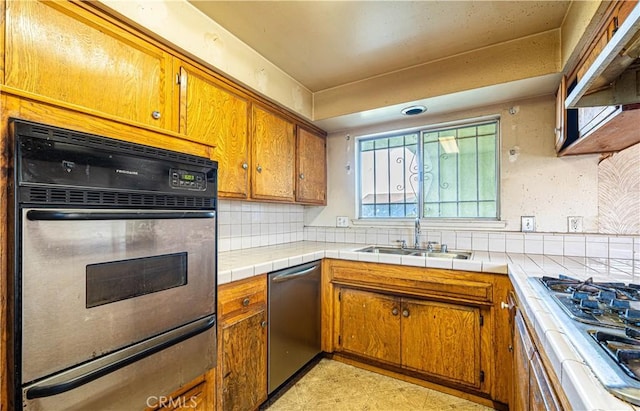 kitchen featuring tile counters, stainless steel appliances, sink, backsplash, and custom range hood