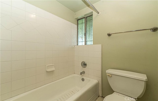 bathroom featuring toilet and tiled shower / bath combo