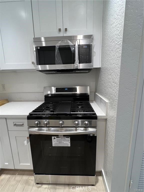 kitchen featuring stainless steel appliances and white cabinets