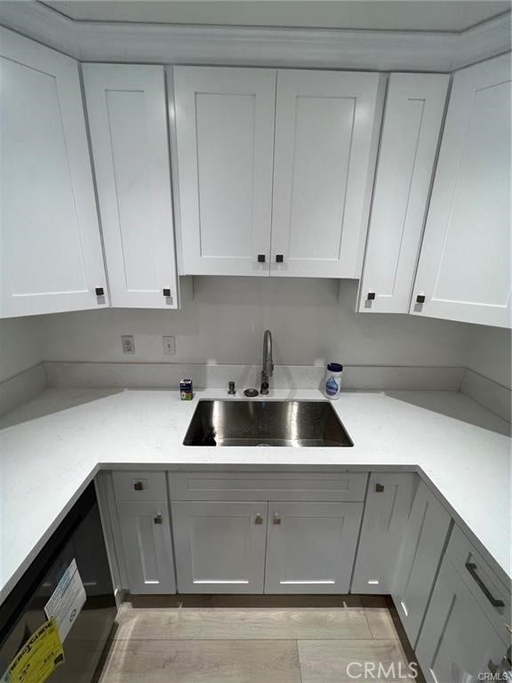 kitchen with sink, white cabinetry, and dishwasher