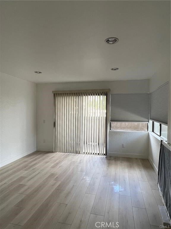 unfurnished room with a wealth of natural light and light hardwood / wood-style flooring