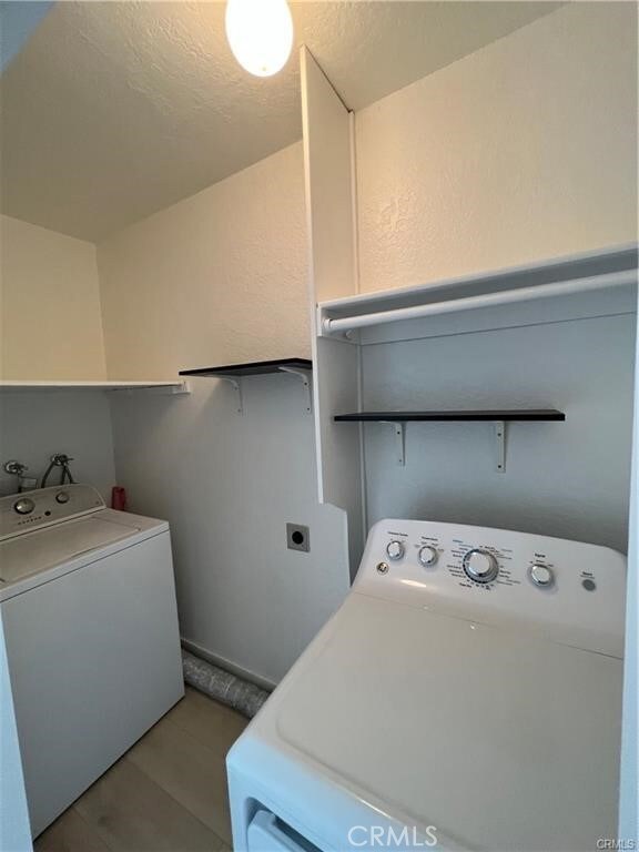 laundry room featuring light hardwood / wood-style flooring and washing machine and dryer