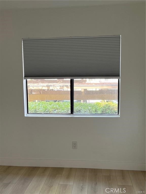 spare room featuring a healthy amount of sunlight and hardwood / wood-style flooring