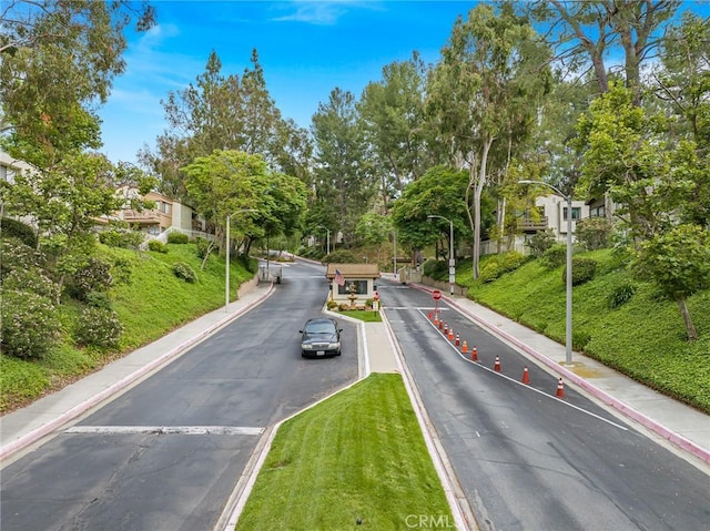 22848 Hilton Head Dr Unit 179, Diamond Bar, CA 91765 - view of asphalt road featuring street lighting, curbs, view of scattered trees, and sidewalks