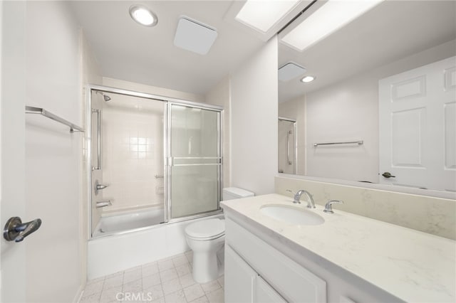 full bathroom with combined bath / shower with glass door, vanity, and toilet