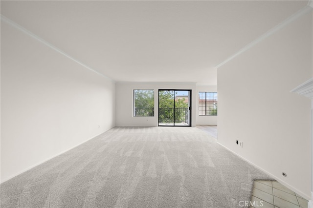 unfurnished living room featuring light colored carpet and crown molding