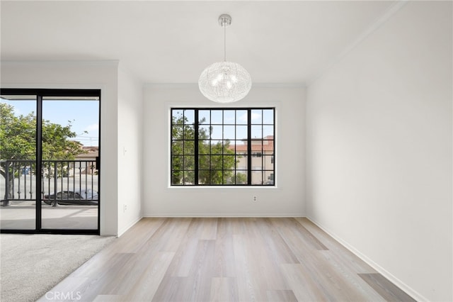 unfurnished dining area with crown molding, a notable chandelier, and light wood-type flooring