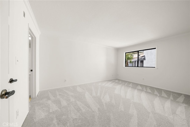 carpeted spare room featuring ornamental molding